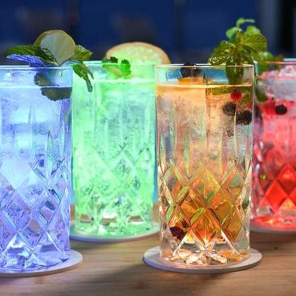 Vier farbig leuchtende Longdrinks am Pool